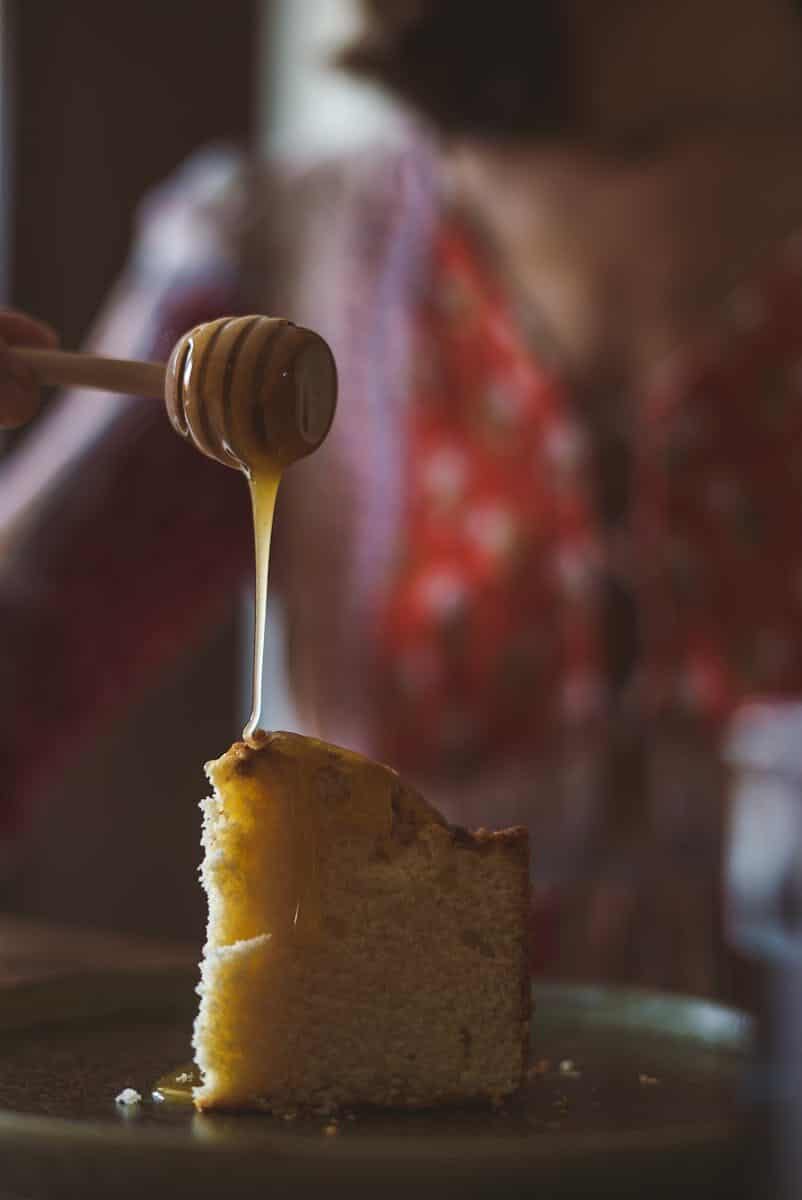 Close-up of a cake slice with honey dripping over it, creating a mouth-watering dessert scene.