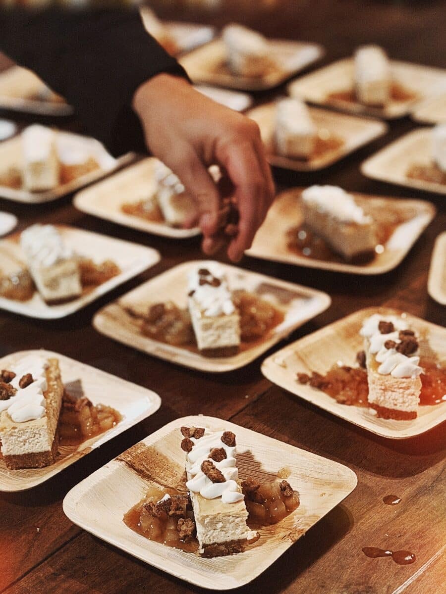 Desserts with whipped cream and nuts served on small plates.
