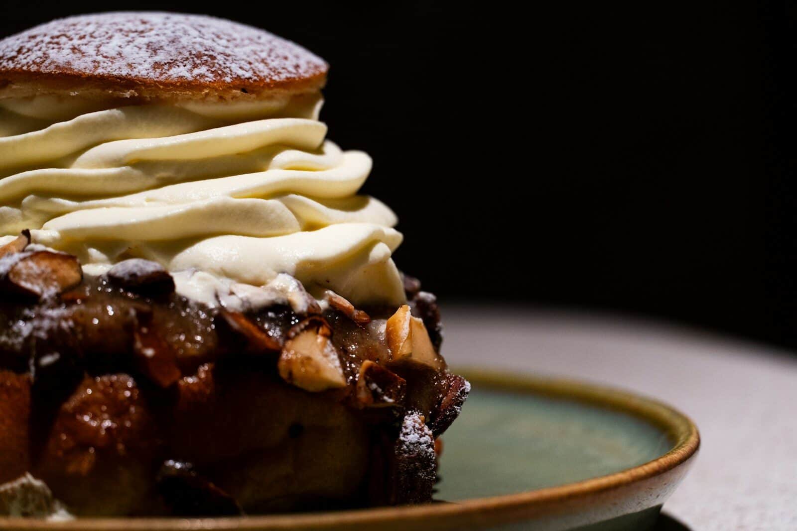 A decadent pastry topped with whipped cream and nuts.